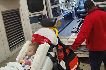 Ellia as a baby being wheeled to ambulance after experiencing an infantile spasm