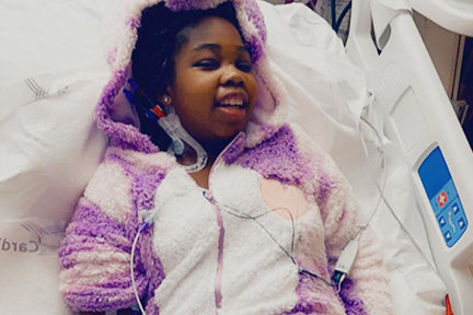 Michaelah, lying bravely in her hospital bed as a little girl, during epilepsy treatment.
