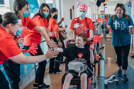 child life team cheering for boy in wheelchair