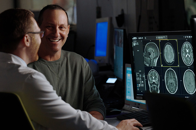 A patient and a doctor looking at brain scans.”